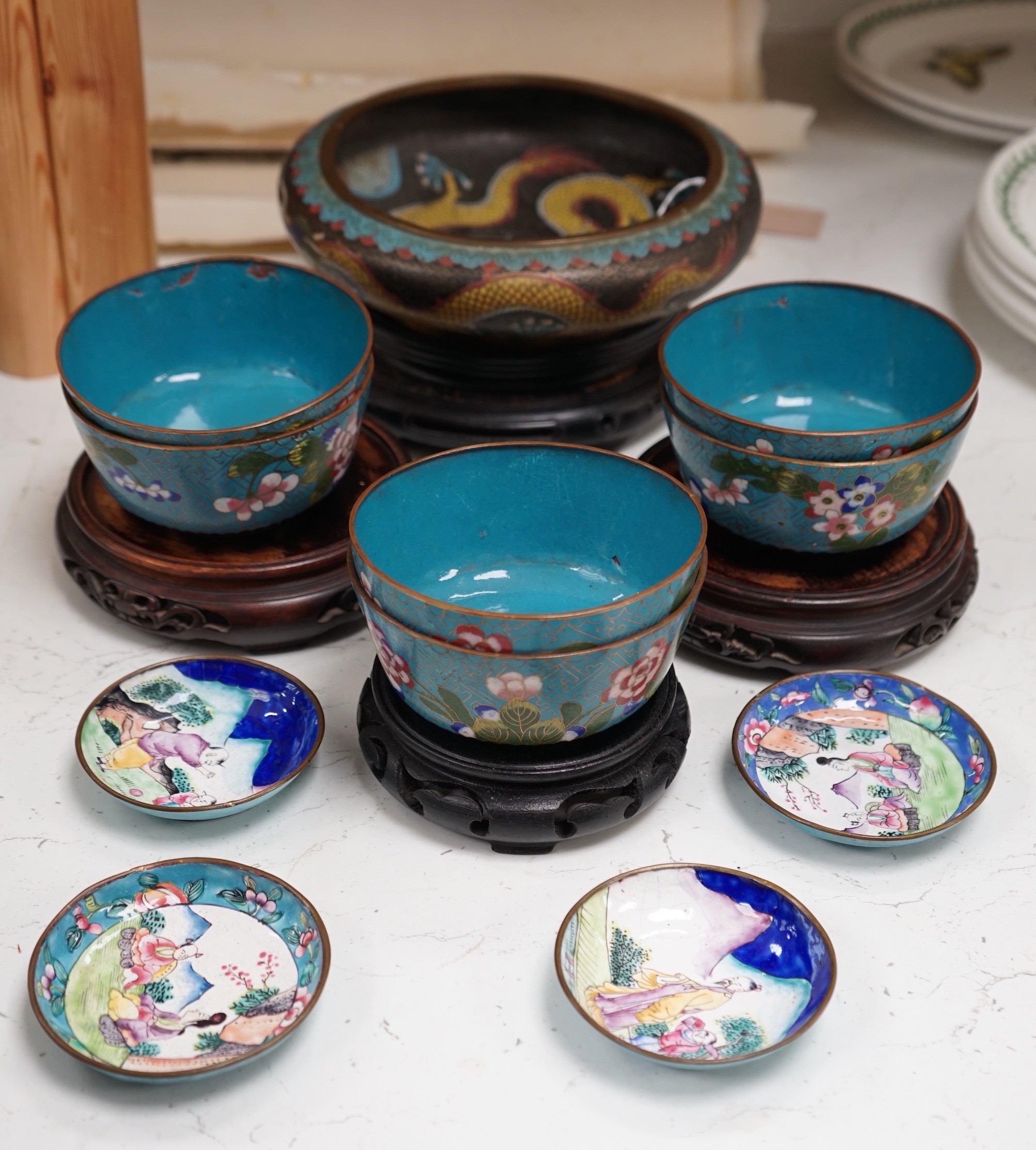 A Chinese cloisonné enamel 'dragon' bowl, six Chinese floral cloisonné enamel bowls and four Canton enamel dishes and wood stands